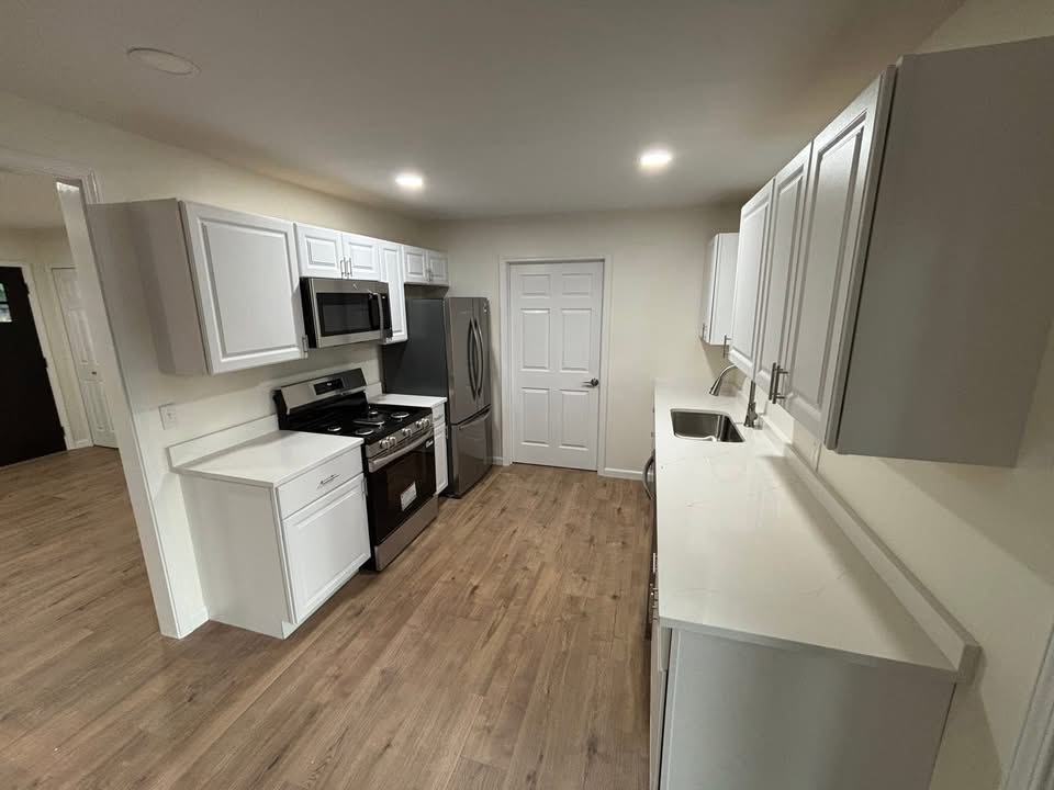 Galley kitchen finished by Done Right Homes — white shaker cabinets and stainless appliances