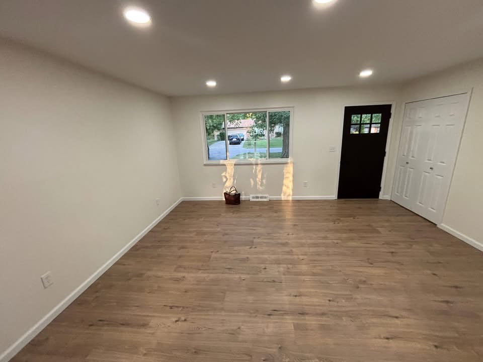 Living room finished by Done Right Homes — luxury vinyl plank floors and recessed lighting